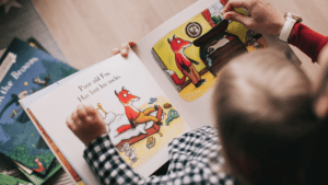 young child sitting on the floor reading a book